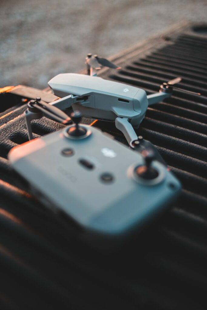 Close-up of DJI Mavic drone and controller on a textured surface at sunset.